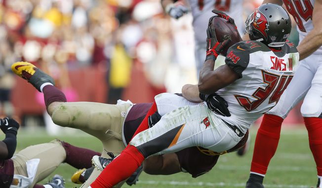 Tampa Bay Buccaneers running back Charles Sims (34) fumbles the ball on a hit by Washington Redskins inside linebacker Will Compton (51) during the second half of an NFL football game in Landover, Md., Sunday, Oct. 25, 2015. The Washington Redskins defeated the Tampa Bay Buccaneers 31-30. (AP Photo/Patrick Semansky)
