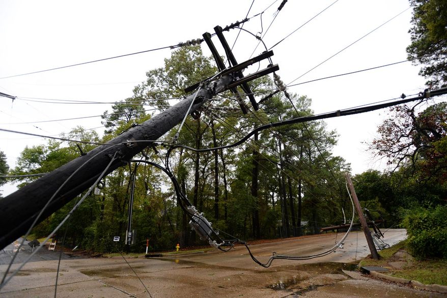 A power line pole is bent over near Pierremont Rd. in Shreveport, La., Monday, Oct. 26, 2015. A massive tree has taken out eight power poles, and more than 160 customers are without power there, with the road closed between Gilbert Drive and Creswell Road. (Henrietta Wildsmith/Shreveport Times via AP)