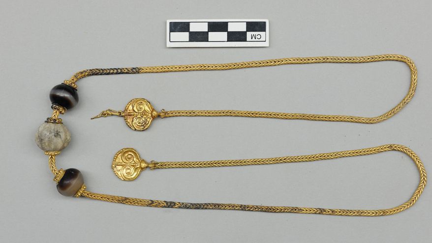 This picture provided by Greece's Culture Ministry on Monday, Oct. 26, 2015, shows - after cleaning - a long gold chain, decorated with semi-precious stones and hammered-gold plant decorations, found in a 3,500-year-old warrior's tomb. Authorities say a 3,500-year-old, treasure-filled grave of a warrior has been discovered near an ancient palace in southern Greece. The Culture Ministry says the grave is the most spectacular discovery of its kind from the Mycenaean era in more than six decades. It contained about 1,400 artefacts, including gold and silver jewelry, cups, bronze vases, engraved gemstones and an ornate ivory-and gilt-hilted sword. (Greek Culture Ministry via AP)