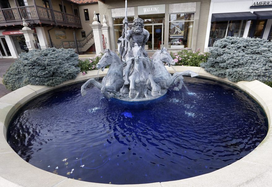 A fountain of Neptune and his Trident is dyed blue in Kansas City, Mo., Monday, Oct. 26, 2015. The color honors the Kansas City Royals second consecutive appearance in the World Series. (AP Photo/Orlin Wagner)