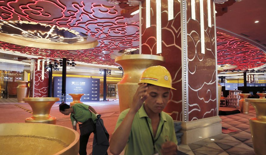 In this Monday, Oct. 26, 2015, photo, workers put the final touches at the Melco Crown Entertainment Ltd.’s $3.2 billion Studio City project one day before the grand opening in Macau, China. China’s world-beating gambling hub is getting a taste of Hollywood glamor as its newest casino resort makes its debut on Tuesday with a glitzy grand opening that hides turmoil behind the scenes. (AP Photo/Vincent Yu)