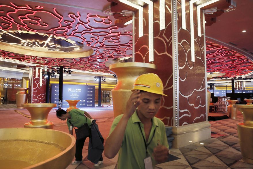In this Monday, Oct. 26, 2015, photo, workers put the final touches at the Melco Crown Entertainment Ltd.’s $3.2 billion Studio City project one day before the grand opening in Macau, China. China’s world-beating gambling hub is getting a taste of Hollywood glamor as its newest casino resort makes its debut on Tuesday with a glitzy grand opening that hides turmoil behind the scenes. (AP Photo/Vincent Yu)