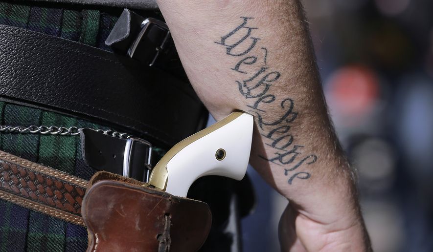 Scott Smith, a supporter of open carry gun laws, wears a pistol as he prepares for a rally at the Capitol on Jan. 26, 2015, in Austin, Texas. (Associated Press) ** FILE **
