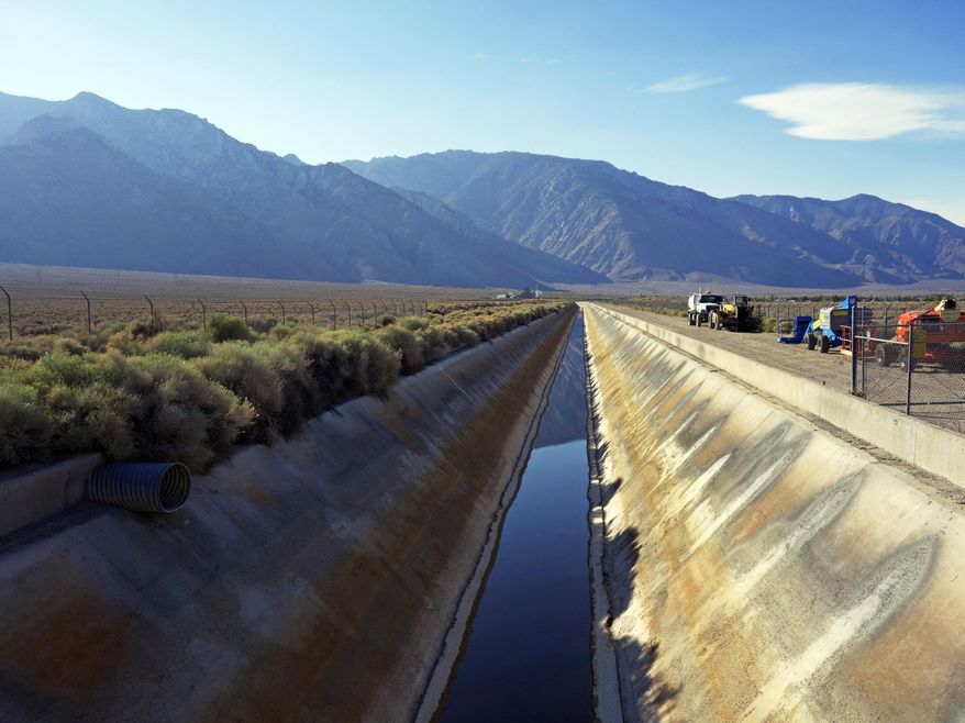 In this Aug. 23, 2015, photo, the Los Angeles Aqueduct has reduced water flow near the eastern Sierra town of Olancha, Calif., after the aqueduct was partially dammed upstream of this area this summer. On Tuesday, Oct. 27, 2015, because of the ongoing drought, water was again flowing south in greater quantities as workers removed the earthen dam that had diverted runoff to the parched Owens Valley. (AP Photo/Brian Melley)