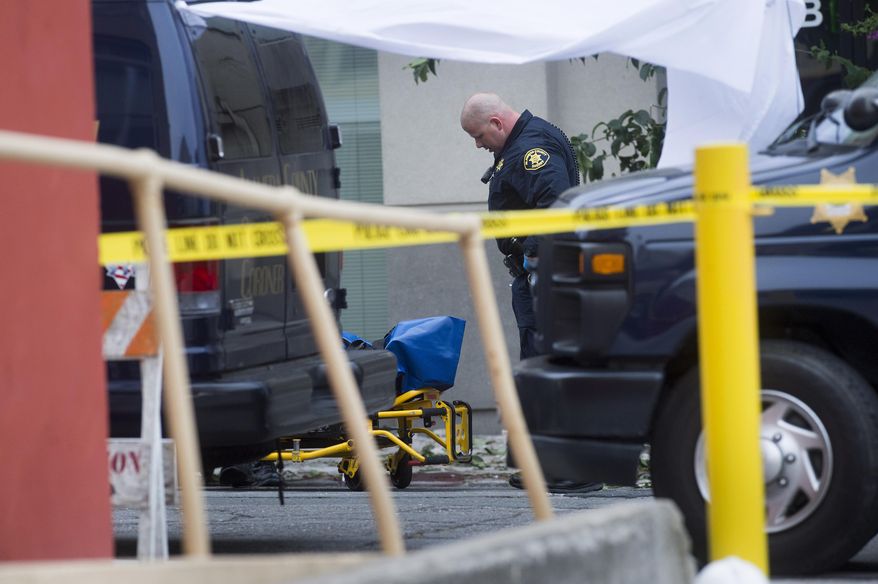 File - In this June 16, 2015 file photo, a sheriff's deputy prepares to move the body of a person who died when a fourth-floor balcony collapsed in Berkeley, Calif. On Wednesday, Oct. 28, 2015, Ireland President Michael Higgins is planning to visit Berkeley to plant a tree in memory of the five Irish college students and one Irish-American who were killed when a balcony snapped off a downtown apartment building. (AP Photo/Noah Berger, file)
