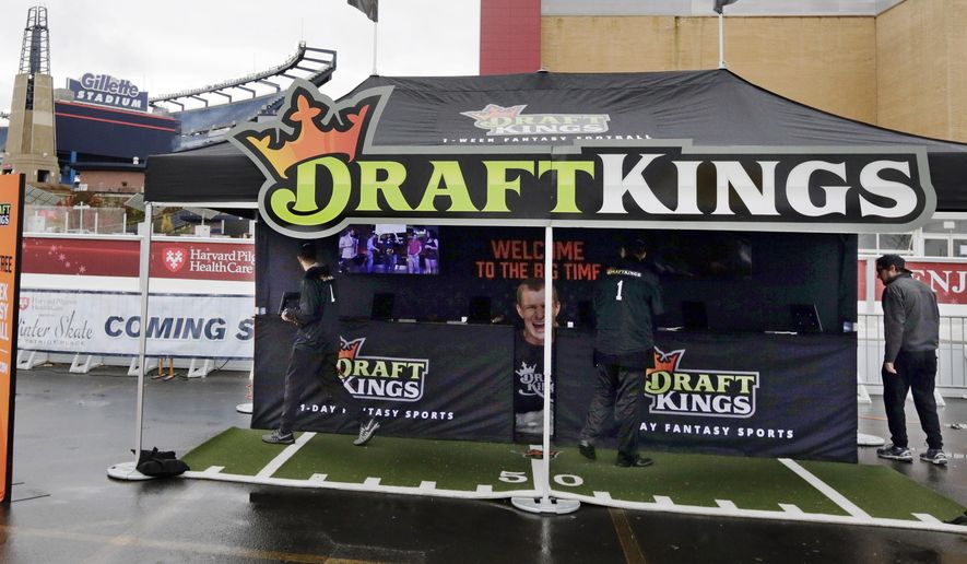 Workers set up a DraftKings promotions tent in the parking lot of Gillette Stadium, in Foxborough, Mass., before an NFL football game between the New England Patriots and New York Jets. The Massachusetts Gaming Commission meets Thursday, Oct. 29, 2015, to discuss regulating daily fantasy sports contests run by Boston-based DraftKings and other companies that have exploded in popularity in recent years. (AP Photo/Charles Krupa)