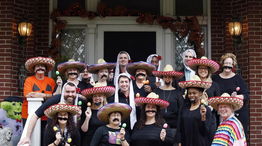 In this Oct. 28, 2015 photo, University of Louisville James Ramsey, lower right, and his wife, Jane, upper left, host a Halloween party in Louisville, Ky. The University of Louisville has apologized after the photo surfaced showing Ramsey among staffers dressed in stereotypical Mexican costumes. (Scott Utterback/The Courier-Journal via AP) NO SALES; MAGS OUT; NO ARCHIVE; MANDATORY CREDIT