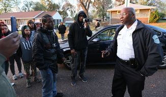 Interim Ferguson, Mo., Police Chief Andre Anderson, right, talks with people Wednesday Oct. 28, 2015, outside the crime scene tape on the 7700 block of Paddington Dr., in Normandy, Mo. Authorities say a St. Louis-area officer who exchanged gunfire with an 18-year-old suspect never hit him, even as the suspect’s father questioned police claims that the suspect killed himself. Amonderez Green of Florissant died early Thursday, 14 hours after a confrontation with a Normandy officer. (Chris Lee/St. Louis Post-Dispatch via AP)
