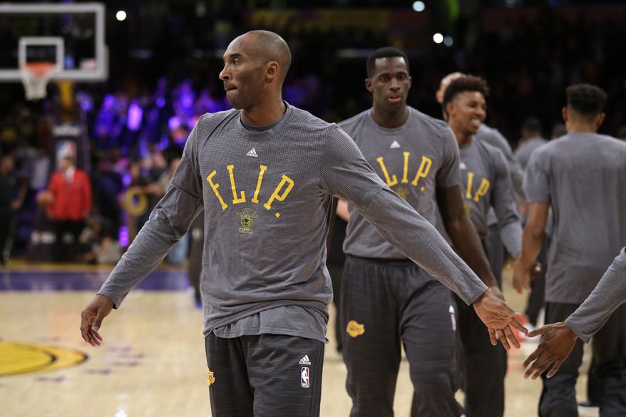 The Los Angeles Lakers players, including Kobe Bryant, front, wear t-shirts in honor of Flip Saunders during pre-game warmups before an NBA basketball game with the Minnesota Timberwolves, Wednesday, Oct. 28, 2015, in Los Angeles. Saunders, a former coach for the Timberwolves, died Sunday. (AP Photo/Jae C. Hong)