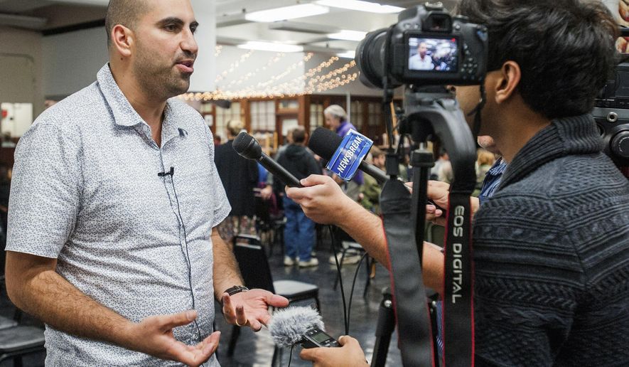 In this Oct. 13, 2015 photo, professor Steven Salaita is interviewed before his talk at the Independent Media Center in Urbana, Ill. University of Illinois Chancellor Barbara Wilson told faculty members at a town hall on Monday, Oct. 26, 2015, that the school hopes to have the lawsuit settled soon that was brought by Salaita, who lost his job offer over a series of profane anti-Israel Twitter messages. (Robin Scholz/The News-Gazette via AP) MANDATORY CREDIT