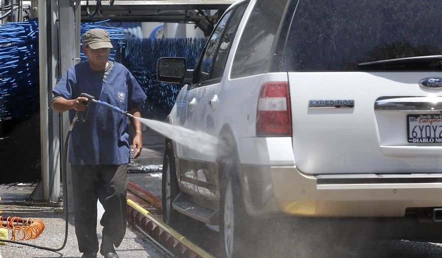 FILE - In this June 24, 2015, file photo, a worker washes a car at Bob's Car Wash in Roseville, Calif. To reduce water use, owner Nancy van Overbeek says the facility had upgraded its recycling and reclamation system and was not watering its lawn. State officials plan to tell Californians what penalties they are taking against communities that fail to meet a mandated 25 percent reduction in water use when they announce usage figures Friday, Oct. 30, in the state’s battle against a widespread drought. (AP Photo/Rich Pedroncelli, File)