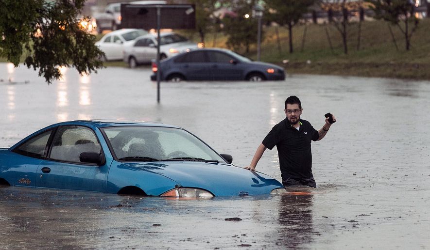 Mike Stoner gets out of his flooded car, Friday, Oct. 30, 2015, in San Marcos, Texas. A fast-moving storm packing heavy rain and destructive winds overwhelmed rivers and prompted evacuations Friday in the same area of Central Texas that saw devastating spring floods. (Rodolfo Gonzalez/Austin American-Statesman via AP)