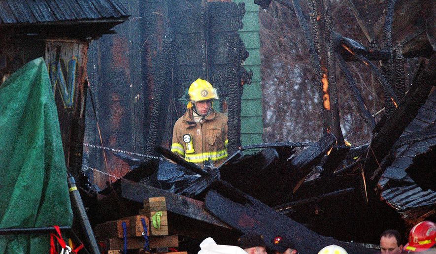 FILE - In this Friday, Feb. 21, 2003 file photo, a firefighter inspects the charred interior of the Station nightclub after a fatal fire at the club in West Warwick, R.I. A deadly nightclub fire at the Colectiv club in downtown Bucharest, Romania has claimed some 27 lives and left at least 180 people injured early on Saturday, Oct. 31, 2015. Several other nightclub fires that have exacted a terrible toll on human lives because of crowded conditions and widespread panic as fire spread quickly throughout crowded, enclosed space. A fire at the Station nightclub in Warwick, R.I., in the United States in February, 2003, killed 100 people and injured more than 200 others. Fireworks being used by the band set fire to flammable foam inside the club. (AP Photo/Michael Dwyer, File)