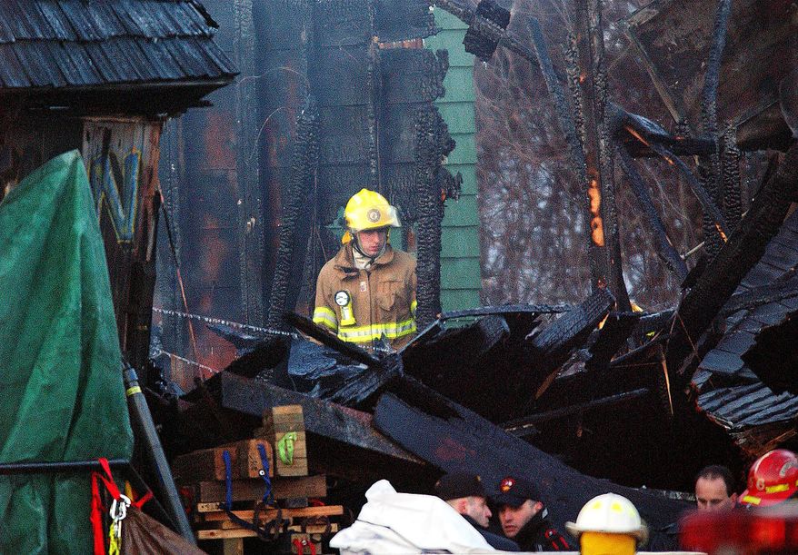 FILE - In this Friday, Feb. 21, 2003 file photo, a firefighter inspects the charred interior of the Station nightclub after a fatal fire at the club in West Warwick, R.I. A deadly nightclub fire at the Colectiv club in downtown Bucharest, Romania has claimed some 27 lives and left at least 180 people injured early on Saturday, Oct. 31, 2015. Several other nightclub fires that have exacted a terrible toll on human lives because of crowded conditions and widespread panic as fire spread quickly throughout crowded, enclosed space. A fire at the Station nightclub in Warwick, R.I., in the United States in February, 2003, killed 100 people and injured more than 200 others. Fireworks being used by the band set fire to flammable foam inside the club. (AP Photo/Michael Dwyer, File)