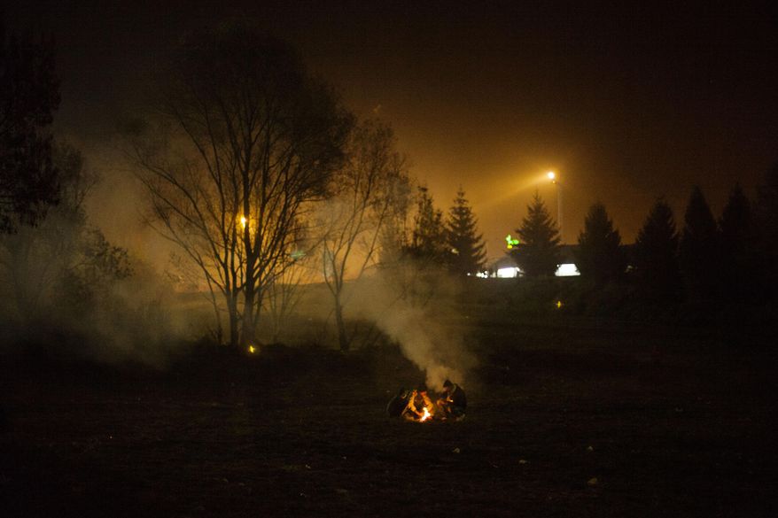 Syrian refugees make a fire while waiting to be allowed to go into Austria at the Slovenian-Austrian border in Sentilj, Slovenia, Monday Oct. 2, 2015. The influx of many hundreds of thousands of migrants into the European bloc over this year, is putting extreme pressure on local communities especially in border countries. (AP Photo /Manu Brabo)