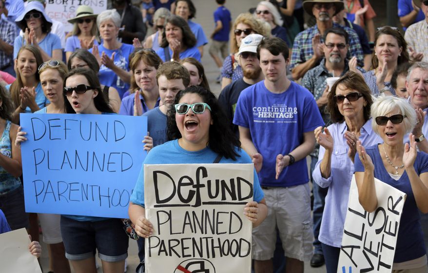 In this July 28, 2015, file photo, Erica Canaut, center, cheers as she and other anti-abortion activists rally on the steps of the Texas Capitol in Austin, Texas, to condemn the use in medical research of tissue samples obtained from aborted fetuses. Texas announced Monday, Oct. 19, 2015, that it was cutting off Medicaid funding to Planned Parenthood clinics following undercover videos of officials discussing fetal tissue, potentially triggering a legal fight like the one unfolding in neighboring Louisiana. (AP Photo/Eric Gay, File)