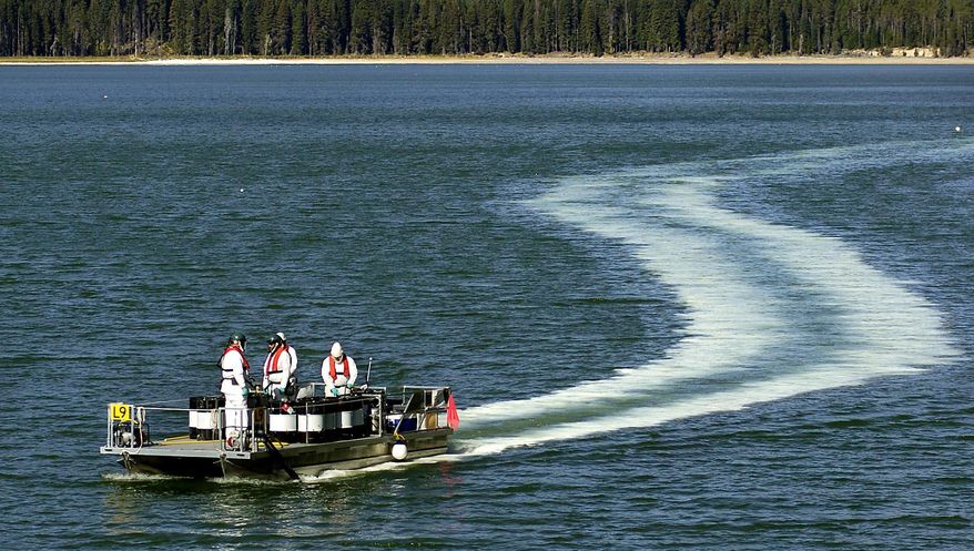 FILE - In this Sept. 14, 2006 file photo, Oregon Department of Fish and Wildlife employees leave a trail of the pesticide Rotenone, used to kill tui chub fish, in the waters of Diamond Lake, Ore. Biologists have found a tui chub at Diamond Lake nine years after the expensive project to eliminate the invasive minnow. Biologists believe tui chub were used illegally as live bait or were intentionally reintroduced into the lake. (Jim Craven/The Mail Tribune via AP, file) MANDATORY CREDIT