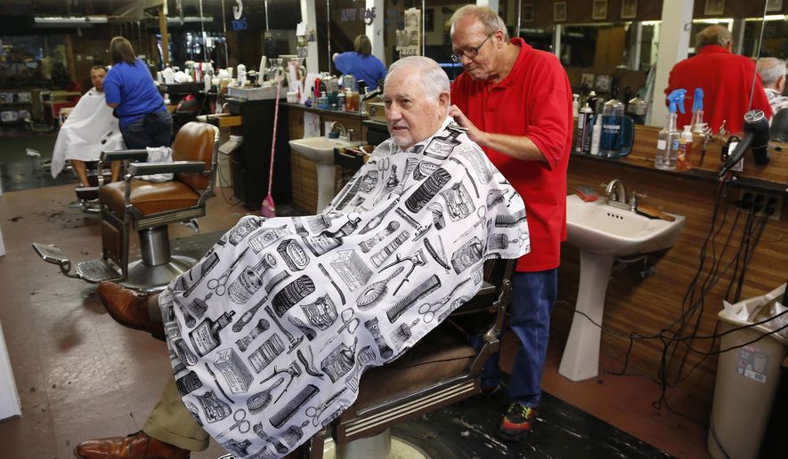 In this Sept. 11, 2015 photo, longtime resident John Soderstrom gets a trim at Barney's barber shop in Ponca City, Okla. The latest oil boom, fueled by horizontal hydraulic fracturing that enabled drillers to tap deep, previously inaccessible oil deposits, brought many back to the oil fields for a big payday. Soderstrom says Welders could make $50 to $75 an hour. (AP Photo/Sue Ogrocki)