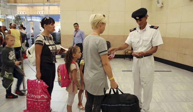 Tourists have their documents checked by Egyptian police as they prepare to be evacuated from Sharm el-Sheikh airport, south Sinai, Egypt, Friday, Nov. 6, 2015. (AP Photo/ Vinciane Jacquet)
