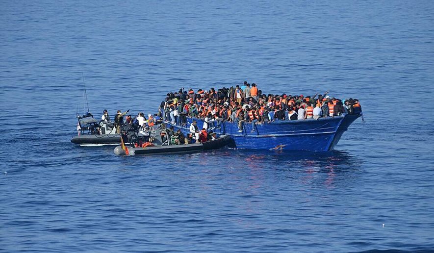 In this hand out photo released by the Spanish Ministry of Defence on Thursday Nov 5, 2015, Spanish rescuers approach to a boat with migrants off the coast of Libya. (Spanish Ministry of Defence via AP)