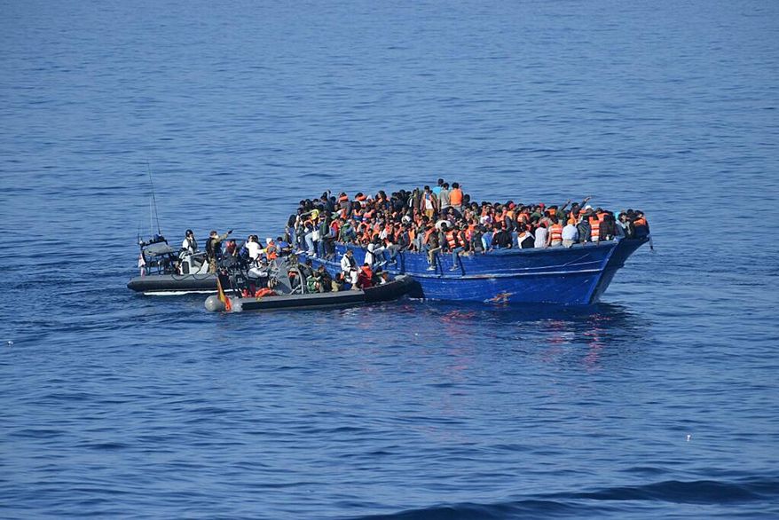 In this hand out photo released by the Spanish Ministry of Defence on Thursday Nov 5, 2015, Spanish rescuers approach to a boat with migrants off the coast of Libya. (Spanish Ministry of Defence via AP)