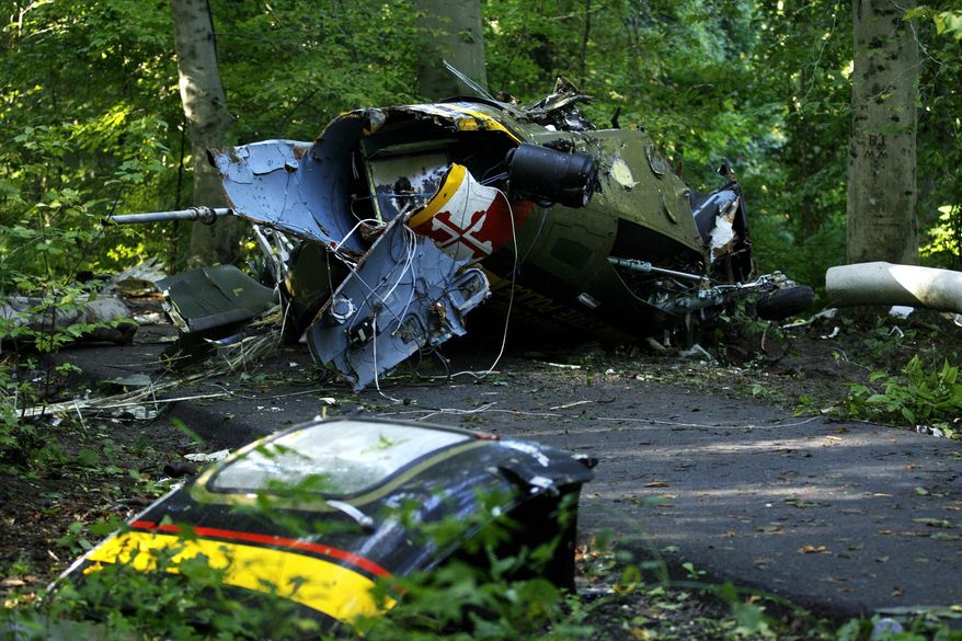 FILE - In this Sept. 29, 2008 file photo, wreckage from the medical helicopter that crashed lies on its side at Walter Mill Regional Park in District Heights, Md. Maryland will unveil a monument Friday for the four people killed in the 2008 crash of a State Police helicopter. (AP Photo/Jose Luis Magana, File)