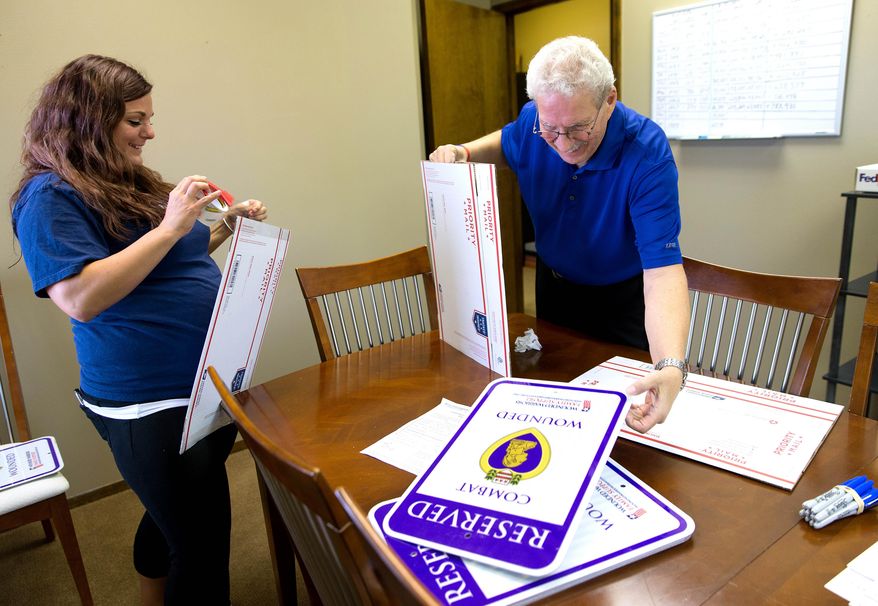 ADVANCE FOR SATURDAY, NOV. 7, 2015 - In this photo taken on Wednesday, Nov. 4, 2015, Ashlie Congdon, left, and Ron Julianelle place "Reserved Combat Wounded" signs in packages before shipping them at Wounded Warrior Family Support, in Omaha, Neb. (Megan Farmer/Omaha World-Herald via AP) MAGS OUT; ALL NEBRASKA LOCAL BROADCAST TELEVISION OUT; MANDATORY CREDIT