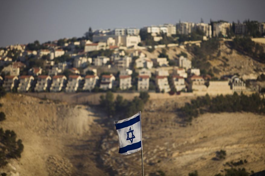 An Israeli flag is seen in front of the West Bank Jewish settlement of Maaleh Adumim on the outskirts of Jerusalem in this Sept. 7, 2009, file photo. (AP Photo/Bernat Armangue, File)