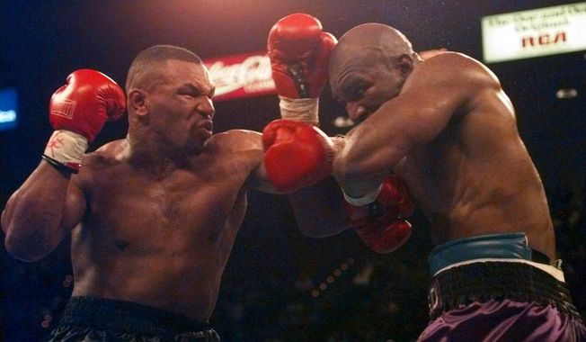 Mike Tyson and Evander Holyfield battle during their WBA Heavyweight Championship bout at the MGM Grand Garden in Las Vegas, Nev., Saturday, Nov. 9, 1996. (AP Photo/ Mark J. Terrill)