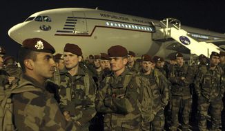 Soldiers stand on the tarmac of the Charles de Gaulle airport, north of Paris, as part of a security reinforcements, Saturday, Nov. 14, 2015. (AP Photo/Michel Spingler)