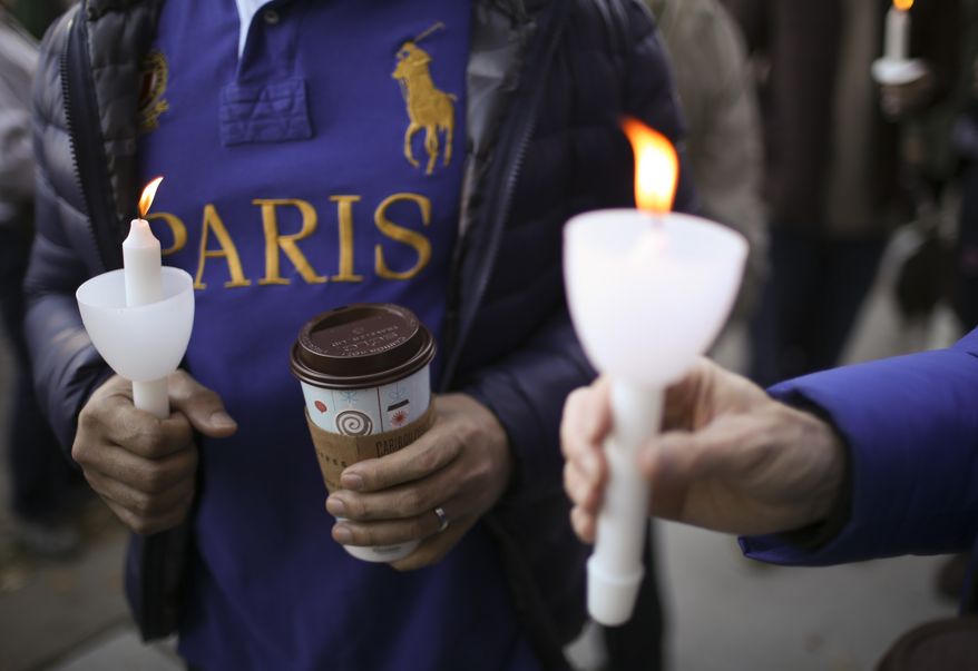 Marchers hold candles as they gathered before a march in Minneapolis, Sunday, Nov. 15, 2015, to show solidarity with France after the deadly attacks in Paris on Friday. (Jeff Wheeler/Star Tribune via AP)