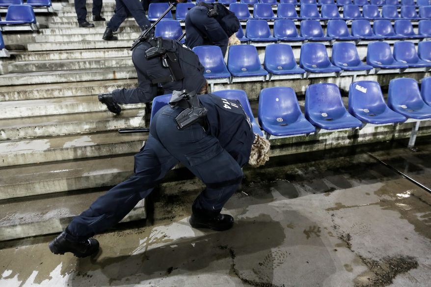 German police officers search between the seats of the stadium prior to a soccer match between Germany and the Netherlands in Hanover on Tuesday. Authorities canceled the game, citing a "concrete" threat of an explosives attack at a stadium. (Associated Press photographs)
