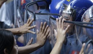 Student protesters clash with police near the U.S. Embassy ahead of the Asia-Pacific Economic Cooperation (APEC) summit in Manila, Philippines Tuesday, Nov. 17, 2015. Leaders of the 21 countries and territories that make up the Asia-Pacific Economic Cooperation forum have begun arriving for the two day meeting which begins here Nov. 18. (AP Photo/Mark Baker)
