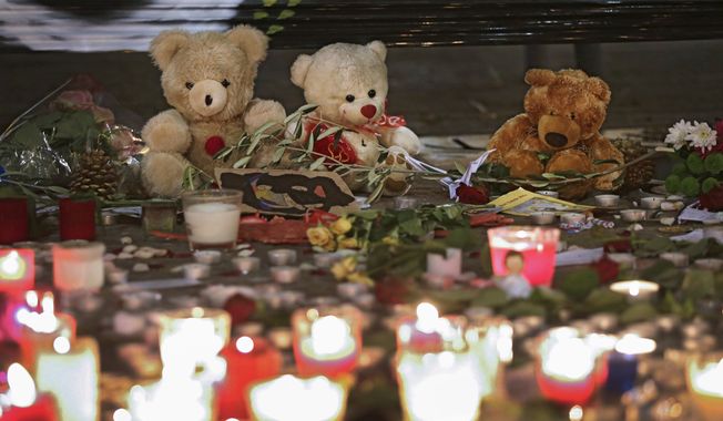 Teddy bears are displayed  to pay tribute to the victims of the terror attacks in Paris, Monday, Nov. 16, 2015, in Nice, southeastern France. France is urging its European partners to move swiftly to boost intelligence sharing, fight arms trafficking and terror financing, and strengthen border security in the wake of the Paris attacks. (AP Photo/Lionel Cironneau)