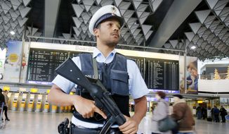 A German police officer guards a terminal of the airport in Frankfurt, Germany, Monday, Nov. 16, 2015. (AP Photo/Michael Probst)