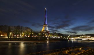 With the River Seine in the foreground the illuminated Eiffel Tower in the French national colors red, white and blue in honor of the victims of the terrorist attacks last Friday, and Seine river are seen in Paris, Wednesday, Nov. 18, 2015. A woman wearing an explosive suicide vest blew herself up Wednesday as heavily armed police tried to storm a suburban Paris apartment where the suspected mastermind of last week&#x27;s attacks was believed to be holed up, police said. (AP Photo/Daniel Ochoa de Olza)