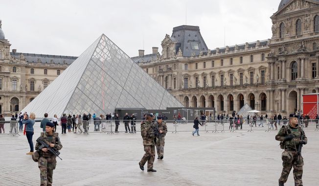 Soldiers patrol in the courtyard of the Louvre museum in Paris in 2015. (Associated Press photographs) ** FILE **