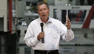 Ohio Gov. John Kasich discusses the state budget with members of local business organizations during a meeting at manufacturing equipment maker Milacron LLC in Batavia, Ohio, in this July 18, 2013, file photo. (AP Photo/Al Behrman, File)
