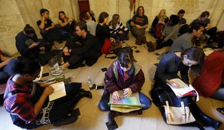 Students gather inside Nassau Hall during a sit-in, Thursday, Nov. 19, 2015, in Princeton, N.J. The protesters from a group called the Black Justice League, who staged a sit-in inside university President Christopher Eisgruber&#39;s office on Tuesday, demand the school remove the name of former school president and U.S. President Woodrow Wilson from programs and buildings over what they said was his racist legacy. (AP Photo/Julio Cortez)