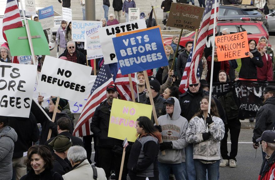 Protesters on opposing sides of the Syrian refugee resettlement issue rally in front of the state Capitol in Olympia, Wash., Friday, Nov. 20, 2015. Washington Gov. Jay Inslee has said the state will welcome refugees and has criticized other governors who have threatened to stop accepting them following last week's terror attacks in Paris. (AP Photo/Rachel La Corte)