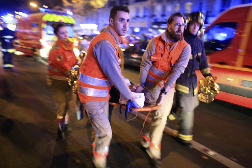 A woman is evacuated from the Bataclan concert hall after a shooting in Paris, in this Nov. 13, 2015, file photo. (AP Photo/Thibault Camus, File)
