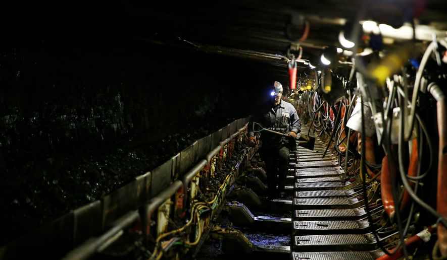 Cory Chanze, shieldman for the Ohio County Coal Company, surveys the longwall operation inside the Ohio County mine in Dallas, West Virginia. Miners are sticking to their preference for such underground work despite the Obama White House attempting to transition them into other lines of work. (Jared Wickerham/Special to the Washington Times)