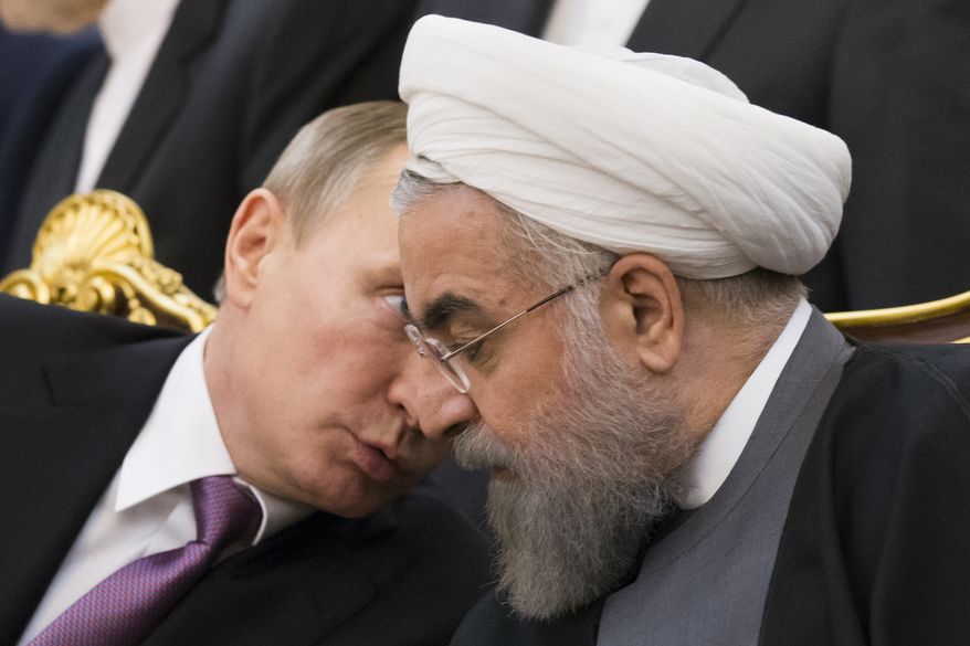 Russian President Vladimir Putin, left, speaks to Iran's President Hassan Rouhani as they attend a signing ceremony during the Gas Exporting Countries Forum (GECF) in Tehran, Iran, Monday, Nov. 23, 2015. The meeting of the Gas Exporting Countries Forum (GECF) bring major producers such as Russia, Qatar and Algeria to Iran, which itself is the world's third largest producer after the U.S. and Russia. (AP Photo/Alexander Zemlianichenko)