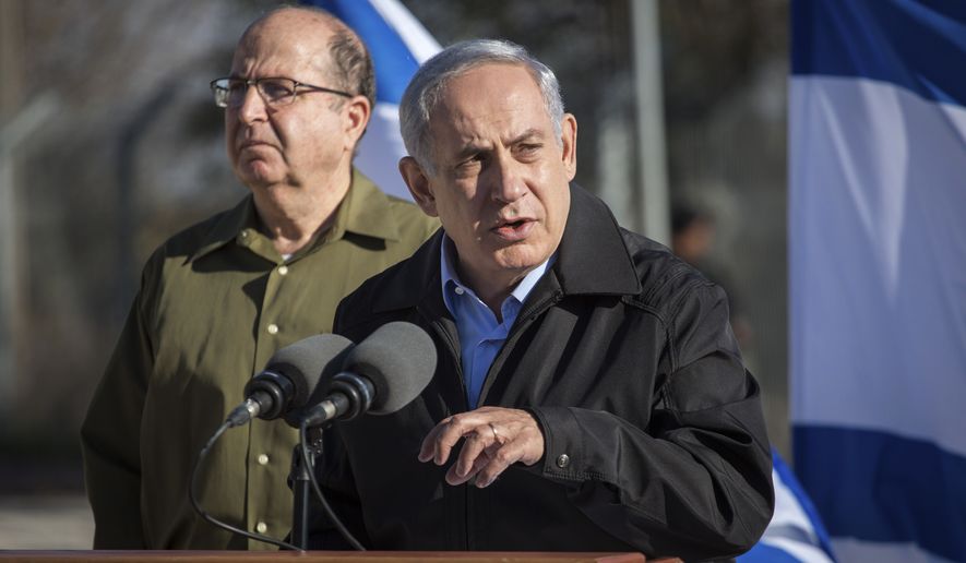 Israel's Prime Minister Benjamin Netanyahu stands with Defense Minister Moshe Yaalon, left, as he speaks during a visit to an army base near the Gush Etzion bloc of Jewish settlements in the West Bank Monday, Nov. 23, 2015. Netanyahu pledged to keep up Israel’s tough hand against Palestinians attackers. (Emil Salman/Pool via AP)