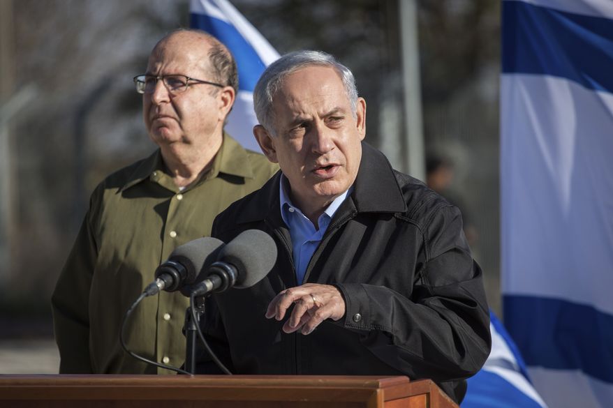 Israel's Prime Minister Benjamin Netanyahu stands with Defense Minister Moshe Yaalon, left, as he speaks during a visit to an army base near the Gush Etzion bloc of Jewish settlements in the West Bank Monday, Nov. 23, 2015. Netanyahu pledged to keep up Israel’s tough hand against Palestinians attackers. (Emil Salman/Pool via AP)