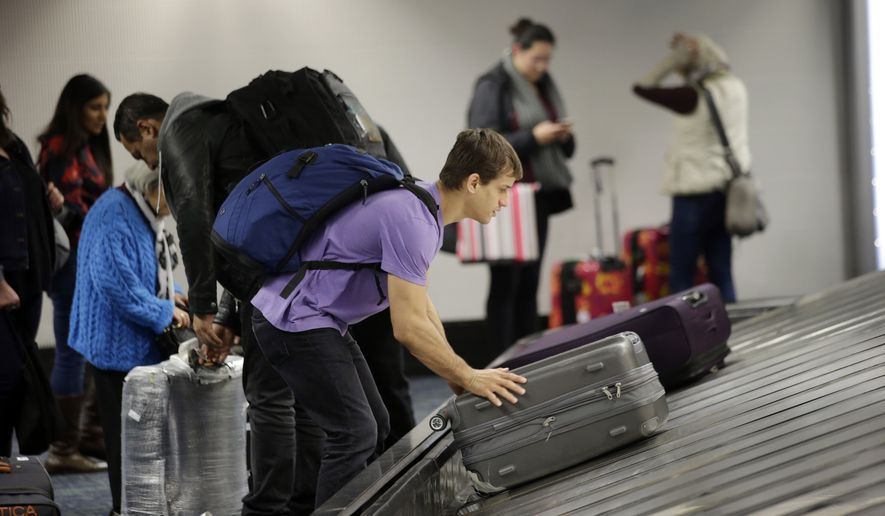 A traveler gathers his luggage at the San Francisco International Airport Sunday in San Francisco. (Associated Press)
