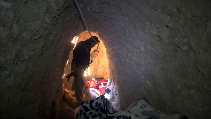 In this image made from video taken on Sunday, Nov. 22, 2015, Kurdish security forces are seen in a tunnel complex under the city of Sinjar, northern Iraq that were used by Islamic State fighters to move undetected and avoid coalition airstrikes before the town was retaken from the militants. (AP Photo via AP video)