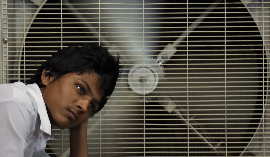 An Indian man rests in front of an air cooler to cool himself on a hot summer day in Hyderabad, in the southern Indian state of Telangana, in this May 31, 2015, file photo. (AP Photo/Mahesh Kumar A., File)