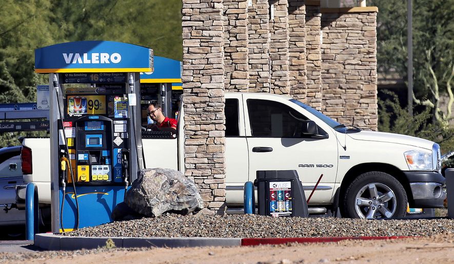 A motorist fuels his vehicle Tuesday, Nov. 24, 2015, in Gilbert, Ariz. With Thanksgiving gas prices at its cheapest since 2008, the number of travelers is expected to rise. (AP Photo/Matt York)