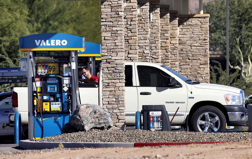 A motorist fuels his vehicle Tuesday, Nov. 24, 2015, in Gilbert, Ariz. With Thanksgiving gas prices at its cheapest since 2008, the number of travelers is expected to rise. (AP Photo/Matt York)